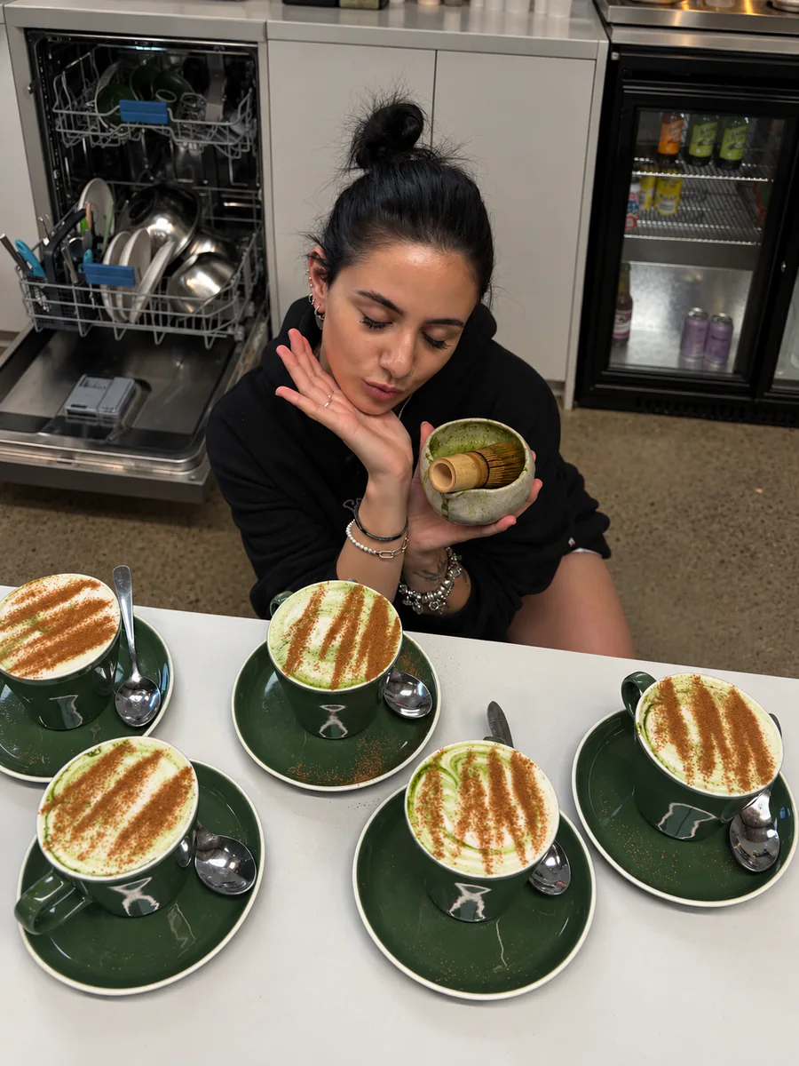 A barista with five cups of coffee