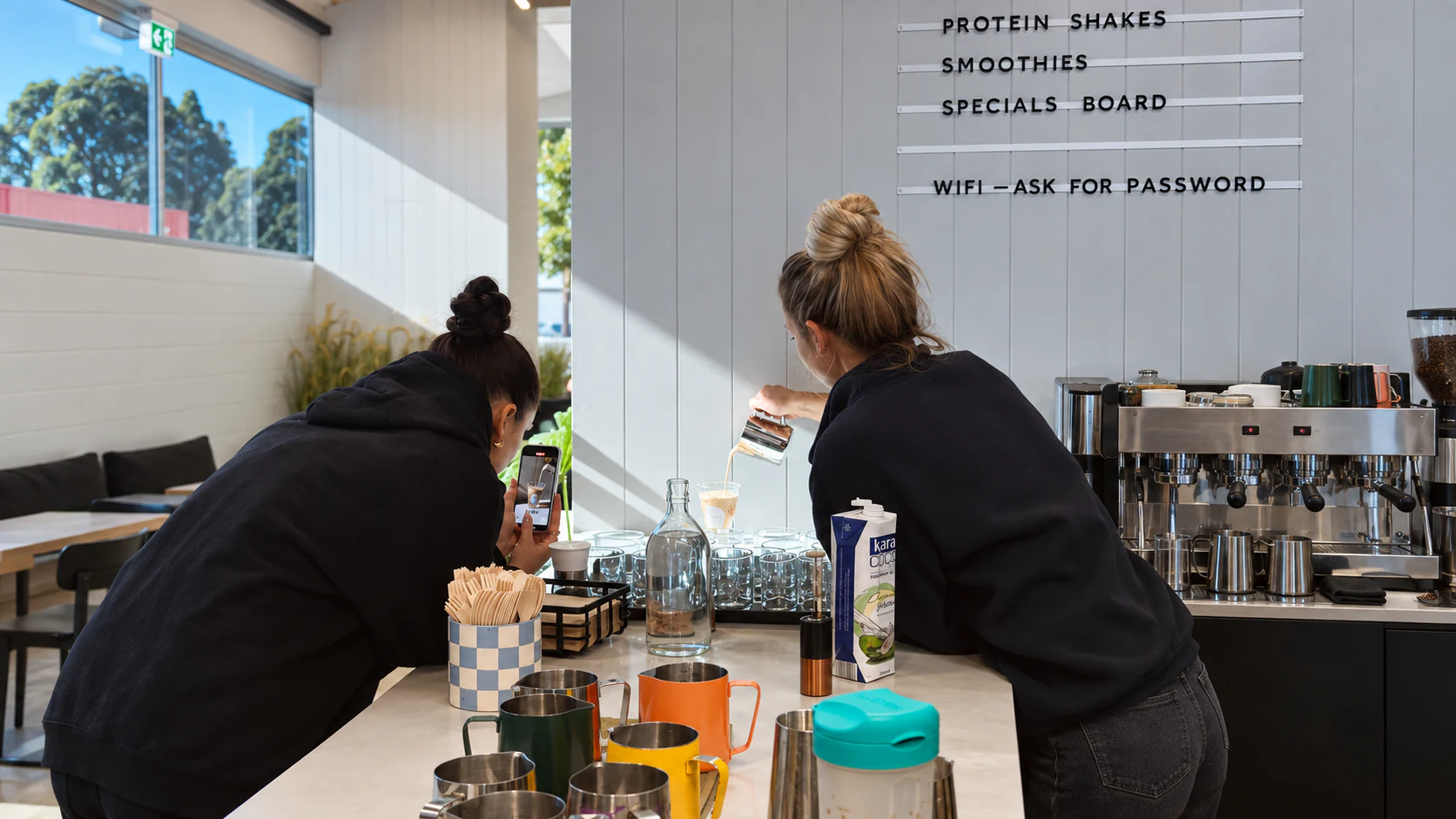 Two people preparing drinks behind the counter